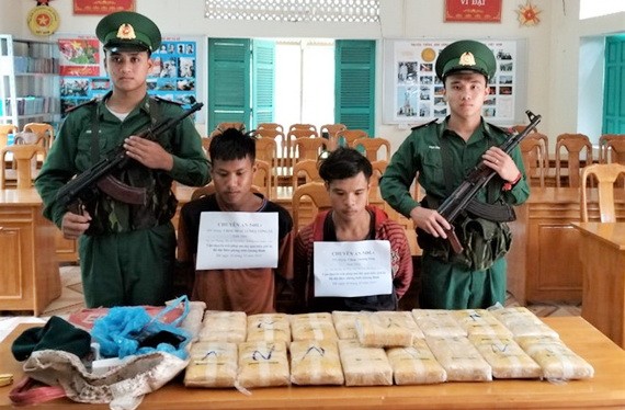被抓獲的2名老撾籍運毒嫌犯與毒品物證。