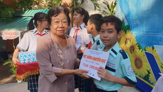 第五郡勵學會主席李金梅向李鋒中學清貧優秀生頒發助學金。