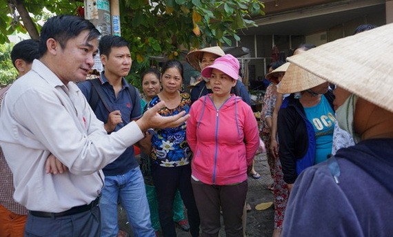 新平郡人委會副主席黎清平（左一）在職時與當地民眾交談。（圖源：嘉明）