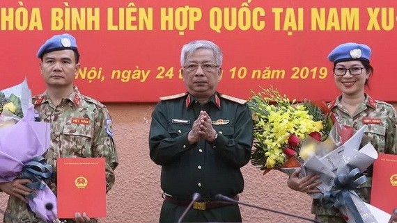 國防部副部長阮志詠上將向參加聯合國維和部隊活動的兩名軍官頒發國家主席的《決定》。（圖源：嘉政）