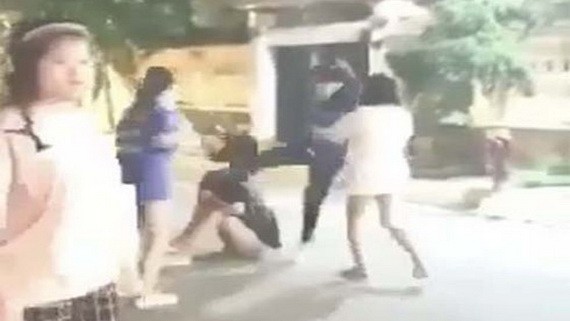 視頻中一名女生被另兩名學生使用安全帽不停地向她的面、頭部及身上亂打。(圖源:視頻截圖)
