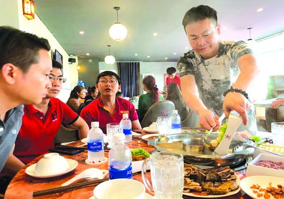 源味火鍋店老闆董先生親自為食客服務。