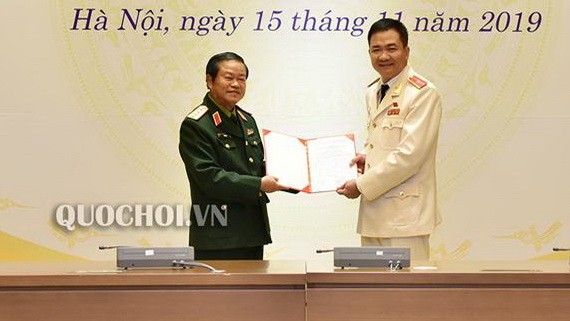 黨中央委員、國會副主席杜伯巳大將（左）向國防安全委員會常務委員阮明德少將頒發國會的國防安全委員會副主任職務的第808號《決議》。（圖源：Quochoi.vn）