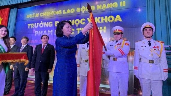 國家副主席鄧氏玉盛代表黨、國家領導向范玉石醫科大學集體和吳明春校長授予二等勞動勳章。（圖源：陳黃）