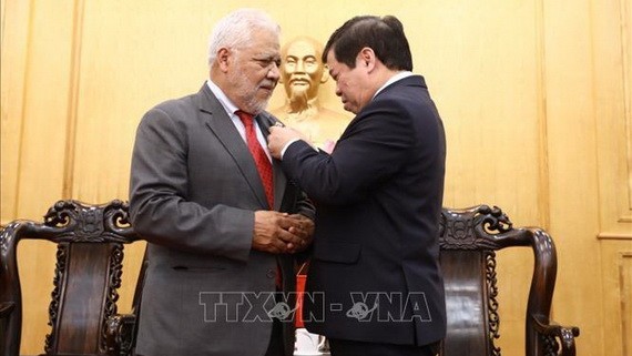 胡志明國家政治學院副院長阮曰草(右)向豪爾赫‧隆東‧烏斯卡特吉大使授予“為政治理論教育與培訓事業”紀念章。(圖源:越通社)