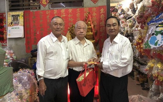 華人商販楊光澤（中）獲福中校友會贈送敬老禮物。