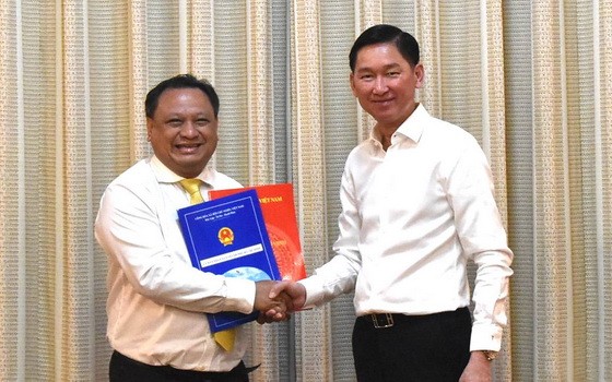 新任第十一郡人委會主席陳飛隆（左）從市人委會副主席陳永線手中接過人事委任《決定》。（圖源：VOH）