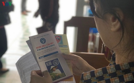 一名婦女在瞭解有關自願社保的繳費額度及相關權益資訊。（圖源：VOV）