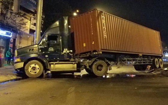 事故現場，集裝箱車橫擋摩托車車道，車頭損壞，潤滑油灑滿路面。（圖源：嘉明）