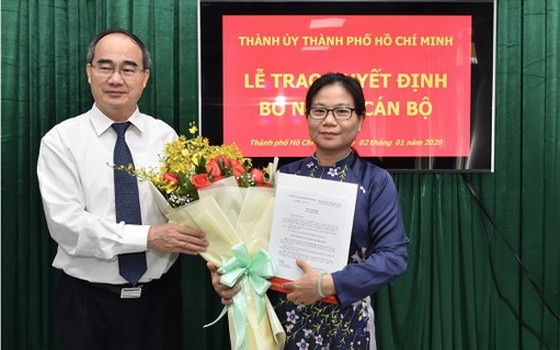 新任市委組織處副主任黎氏清翠（右）從市委書記阮善仁手中接過人事委任《決定》和祝賀鮮花。（圖源：越勇）