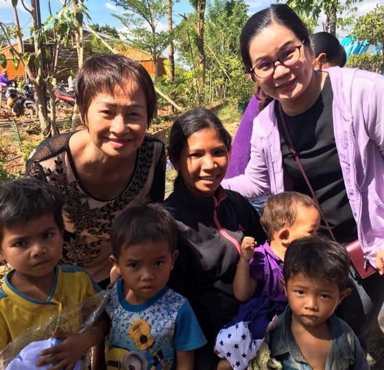 華人商販應氏蓮(後排左一)與貧困戶及兒童合影。