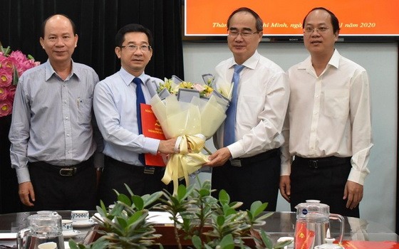 新任市委內政處主任楊玉海（左二）從市委書記阮善仁手中接過人事委任《決定》及祝賀鮮花。（圖源：豐宇）