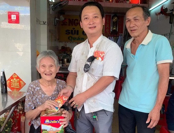 崇正興寧福利組理事長鄒國榮（中）向高齡鄉親贈送新年禮物。