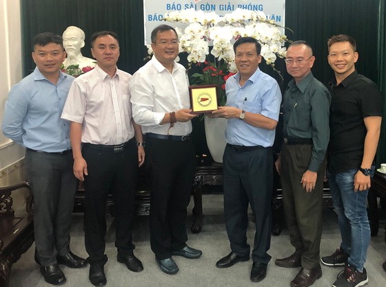 趙騫會長(左三)向本報領導贈送花籃與紀念品。