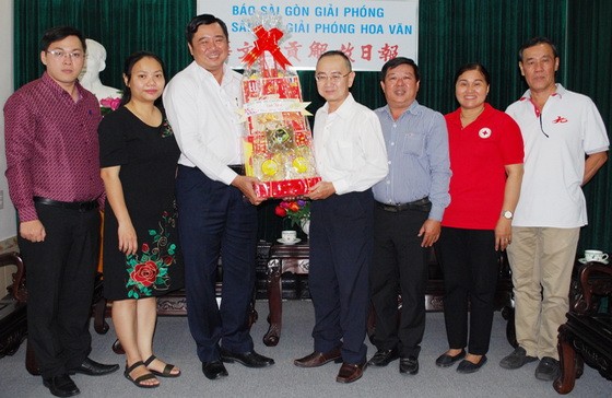 本報編委兼編輯部主任范興(右四)接領第八郡代表團的新年禮物。