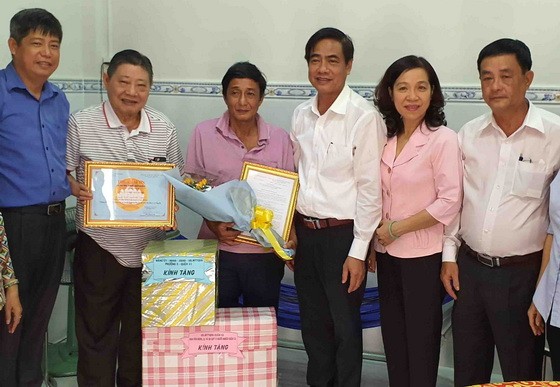 杭慰瑤董事長(左二)與吳文論書記(右三) 向貧戶移交溫情屋及春節禮物。