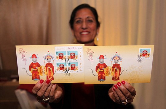 圖為加拿大郵政公司員工展示鼠年郵票加拿大國內版首日封。（圖源：互聯網）