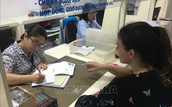 一名外籍女士前來第三郡人委會辦事處辦理行政手續。（圖源：越通社）