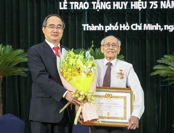 市委書記阮善仁向阮春命同志頒授 75 年黨齡紀念章。（圖源：草黎）