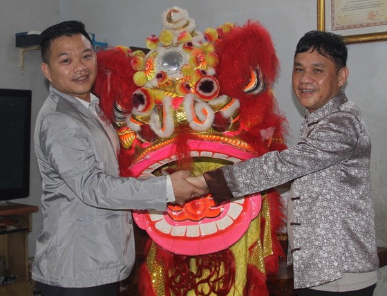 徐梓衡師傅（右）向筆者贈送一套醒獅。