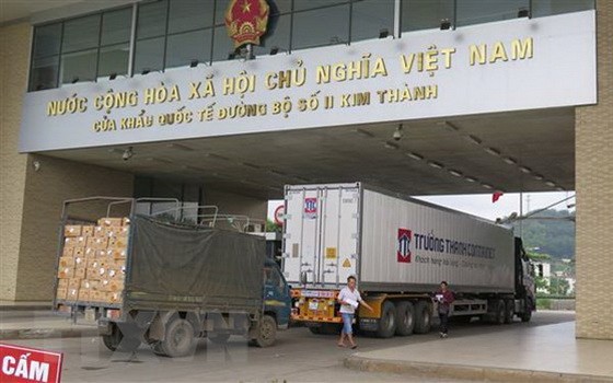 兩輛運載農產品的貨車經老街金城口岸通關運往中國。（圖源：越通社）