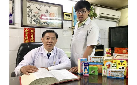 鍾世強醫師（左）與三子興榮探討醫術。