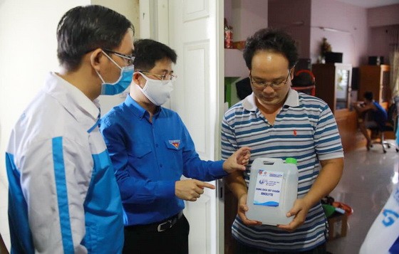 青年向人民贈送消毒洗手液。