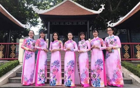 第十一郡婦聯會的越、華婦女穿著長衫拍照。