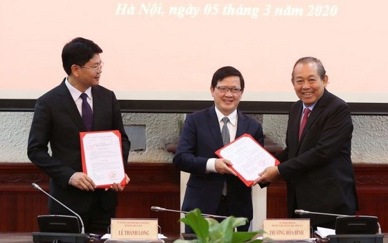 政府常務副總理張和平（右）向兩位新任司法部副部長頒授職務調任《決定》。（圖源：黎山）