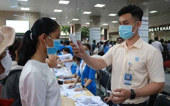 醫護人員為來診病人檢測體溫。