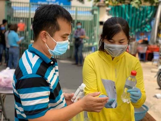 第十郡第十四坊婦女會成員向隔離區居民贈送抗菌洗手液並引導如何正確且有效使用洗手液。