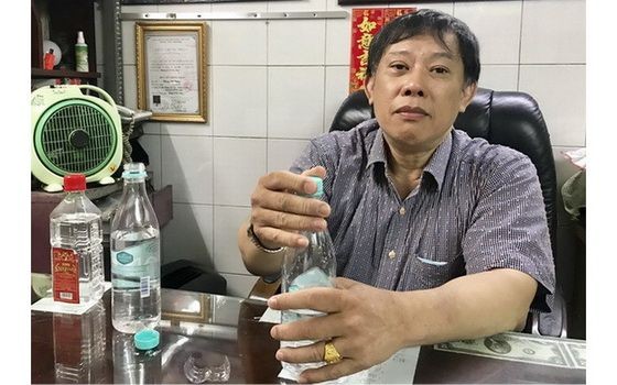 鍾世強醫師示範把白酒和清水溶合動作。