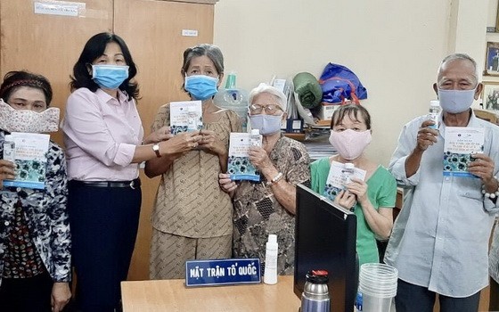 陳月梅主席（左二）向人民贈送口罩。