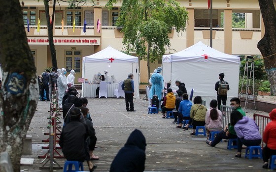 昨(31)日上午，河內市衛生廳與市疾病監控中心在棟多郡金蓮坊棟多中學與地方政府配合，為白梅醫院周邊居民設立新冠肺炎病毒採樣快速檢測點。（圖源：TNO）