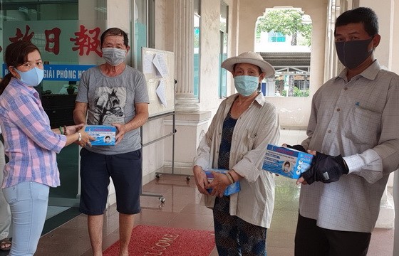 本報副執行編輯陳月寶(左一)代表向報販贈送口罩。