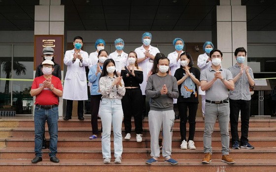 在中央熱帶病醫院收治的11 名新冠肺炎患者痊愈出院前與醫護人員合照。（圖源：玉成）