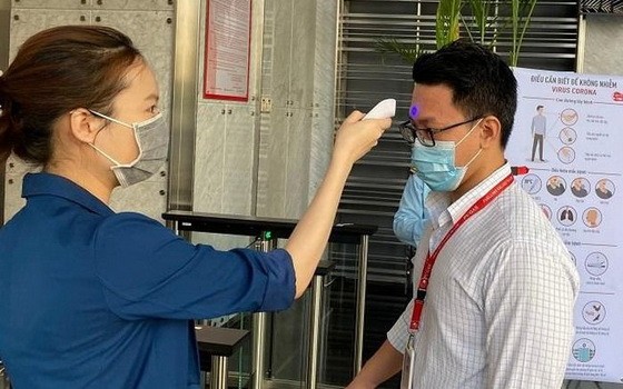 出入公寓民眾都要量體溫。（圖源：范孟）