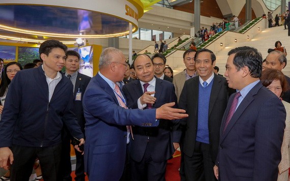 從本月9日上午8時開始，政府總理將與企業界舉行線上對話會。圖為2019年政府總理阮春福在會議場外同企業家們交流。（圖源：越勇）