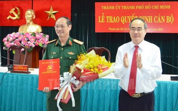 市委書記阮善仁向陳文南少將頒授《決定》並送鮮花祝賀。（圖源：市黨部新聞網）