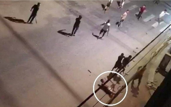 兩夥青年因發生爭執導致互毆，手持利器在一陣亂砍混戰中，一名青年（白圈示）不幸被砍斷手臂倒地，隨後獲送醫院搶救，但其後不治身亡。（圖源：視頻截圖）