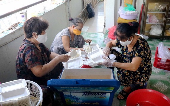 阮氏調（右）與姐妹們準備飯菜送給貧困者。