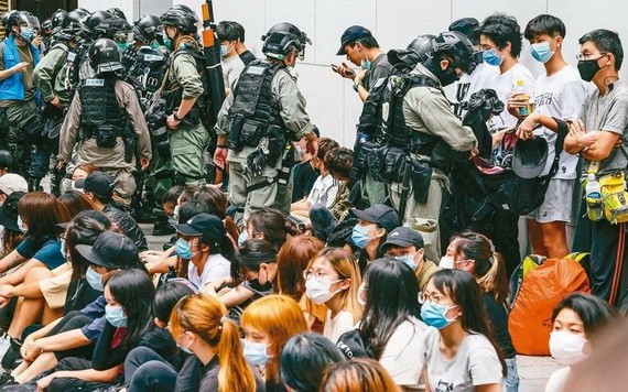 圖為香港警方留置抗議港版國安法的香港民眾後,打開他們的背包檢查。 (圖源:歐新社)