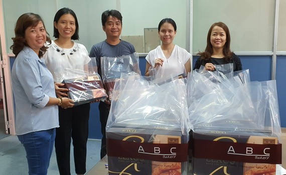 本報工會副主席陳月寶（左一）代表工會接收禮物和派發給有少兒子弟的工會會員。