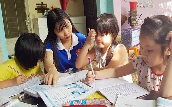 共青團團員給少兒輔導功課。（圖源：黎維）
