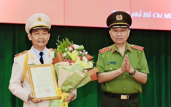 公安部長蘇霖大將（右）受國家主席的委託，向市公安廳副廳長丁清閑（左）頒授晉升少將警銜《決定》。（圖源：市公安廳）