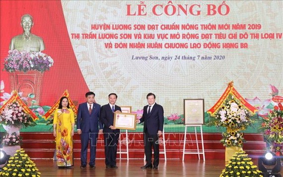 政府副總理鄭廷勇(右一)出席政府總理公認和平省良山縣達2019年新農村標準的《決定》公佈儀式。(圖源:越通社)