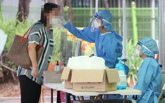 韓國首爾江西衛生站的篩查診所一名市民接受體溫檢測。(圖源:韓聯社)