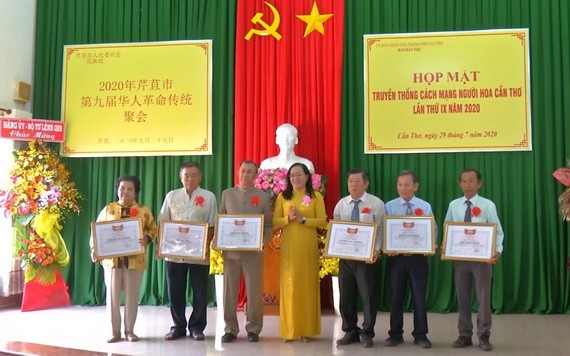 芹苴市越南祖國陣線委員會副主席阮翠姮(中)向華人同胞集體典範代表頒發獎狀。(圖源:芹苴電視台)