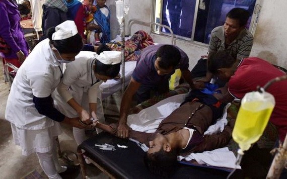 醫護人員正在搶救飲用假酒的中毒者。（圖源：AFP）