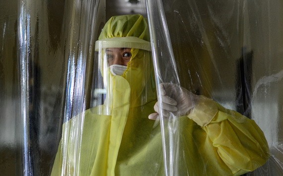 菲律賓色阿拉，一位女醫生拉起作為“紅區”分隔的塑料布簾。（圖源：聯合國）